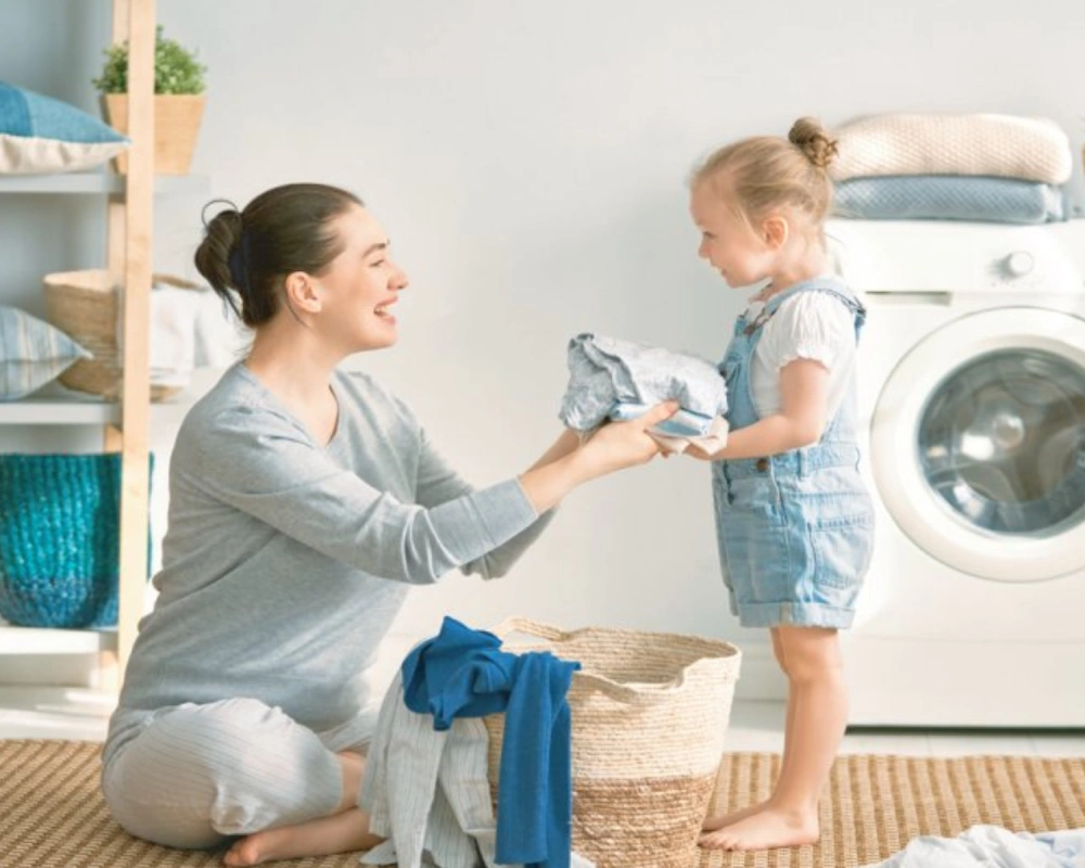 Mother and child folding clothes, emphasizing quality dry cleaning for garment care.